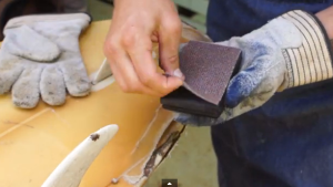 Here we've modified our rubber sanding block and we've attached our 40 grit abrasive instead of sandpaper.